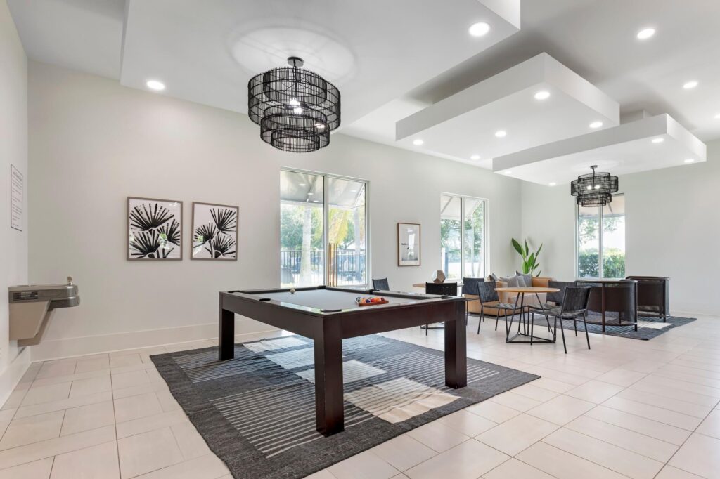 Clubhouse game area with pool table couch, tables and chairs