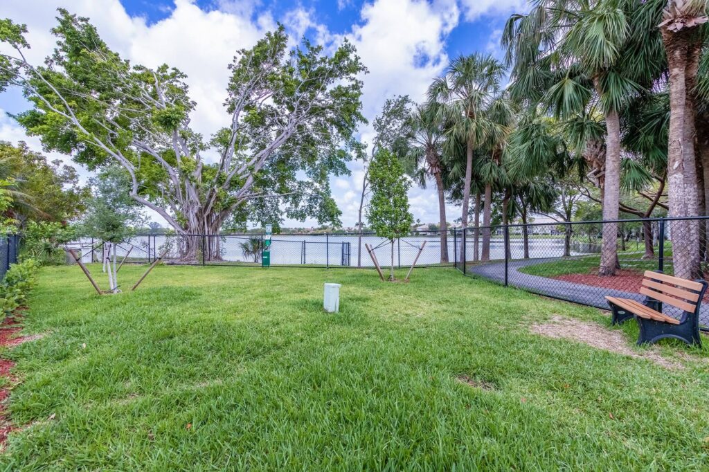 Gated dog park with waste basket and bench