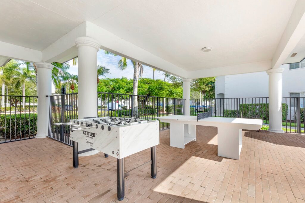 Covered outdoor area with foosball table and ping pong table
