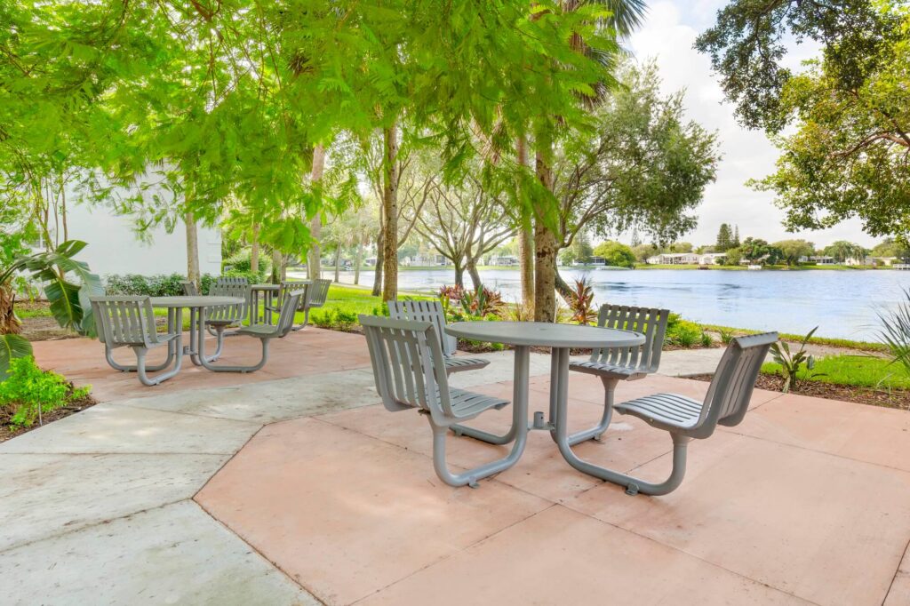 Outdoor tables and chairs with view of the lake and lots of trees
