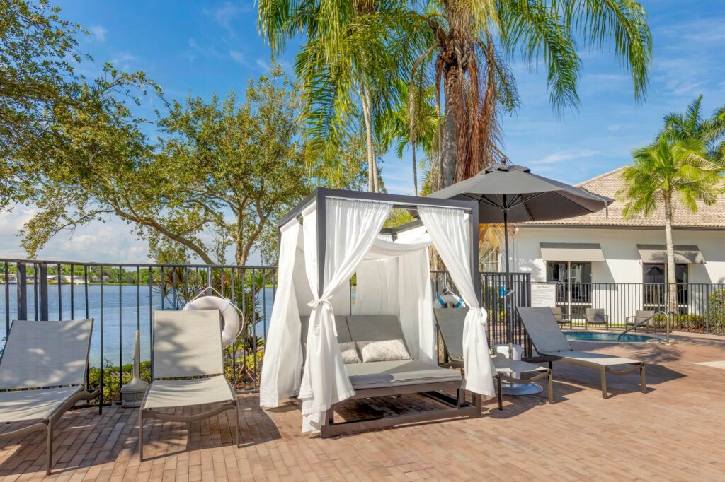 Pool lounge chairs with cabana and spa area in the back